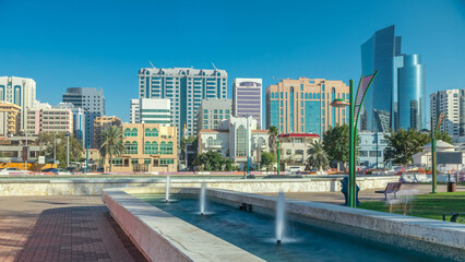 Corniche boulevard beach park along the coastline in Abu Dhabi timelapse with skyscrapers on...