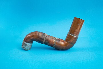 S shaped copper pipe used for heating system, on blue background