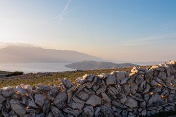 Dry stone wall with aerial view of moon plateau seen from mountain top Hlam in Baska, Krk Island,...