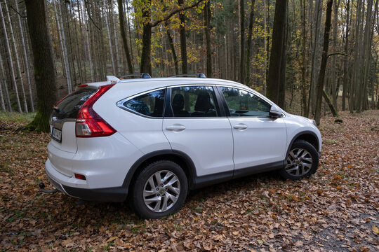 Prague, CZ -25.10.2022: SUV parked in an autumn forest, surrounded by nature. white Honda CRV from the 2015 release year. Editorial