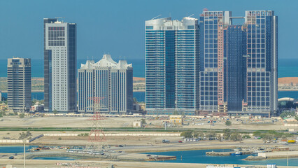Fototapeta premium Buildings on Al Reem island in Abu Dhabi timelapse from above.