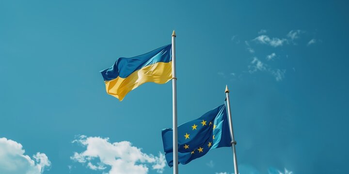 Ukraine and European Union flags side by side against a clear sky