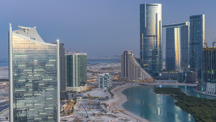 Buildings on Al Reem island in Abu Dhabi day to night timelapse from above.