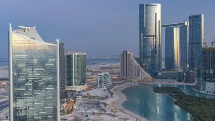 Gordijnen Buildings on Al Reem island in Abu Dhabi day to night timelapse from above. © neiezhmakov