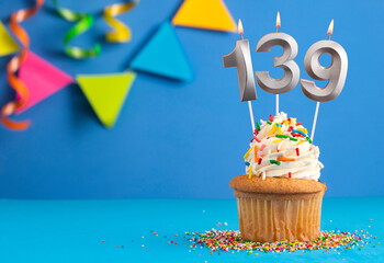 Birthday cupcake with candle number 139 - Blue background