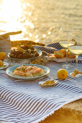 Table full of seafood and vegetable dishes with sea horizone in the background