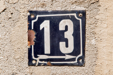 Weathered grunge square metal enameled plate of number of street address with number 13