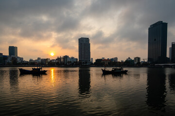 Fototapeta premium Sunset behind the skyline and fishing boats of Da Nang in Vietnam
