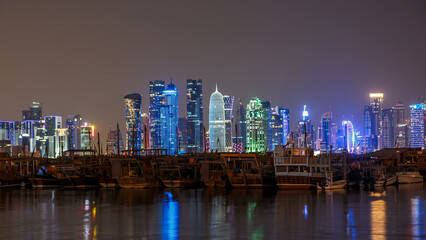 Fototapeta premium A panoramic view of the old dhow harbour night timelapse in Doha, Qatar, with the West Bay skyline in the background.