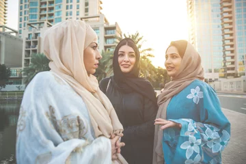 Fotobehang Three women friends going out in Dubai. Girls wearing the united arab emirates traditional abaya © oneinchpunch