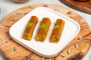 Kadayıf with pistachios on a wooden background. Turkish cuisine delicacies. Ramadan Dessert. local name burma kadayif