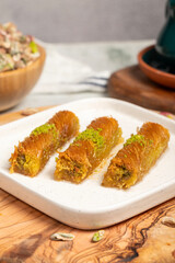 Kadayıf with pistachios on a wooden background. Turkish cuisine delicacies. Ramadan Dessert. local name burma kadayif