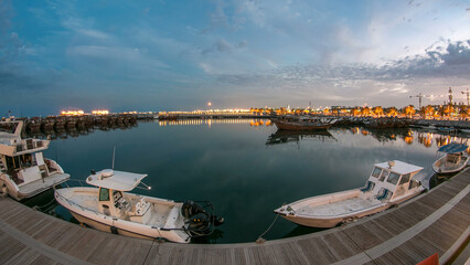 Fototapeta premium Fishing boat parked near the fish market next to Kuwait City Area day to night timelapse