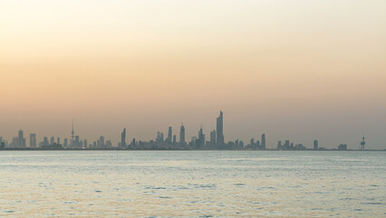 Skyline with Skyscrapers day to night timelapse in Kuwait City downtown illuminated at dusk. Kuwait...