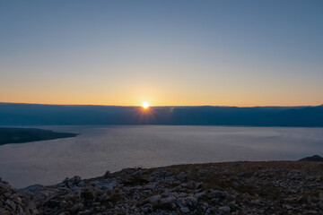 Fototapeta premium Panoramic view of sunrise over karst mountains along idyllic hiking trail near coastal town Baska, Krk Otok, Primorje-Gorski Kotar, Croatia, Europe. Majestic coastline Mediterranean Adriatic Sea