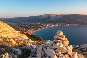 Stone cairns with scenic sunrise view of coastline of Mediterranean Adriatic Sea in coastal town...