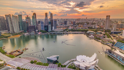 Panorama of Singapore Marina Bay with Financial District skyscrapers at sunset light reflected on...