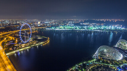 Skyline of Singapore with famous Singapore Ferries Wheel night timelapse