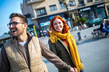 Smiling couple enjoying on vacation, young tourist having fun walking and exploring city street during the day.