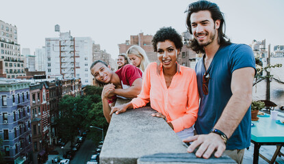 Group of friends spending time together on a rooftop in New york city, lifestyle concept with happy people