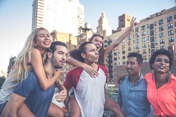 Group of friends spending time together on a rooftop in New york city, lifestyle concept with happy...
