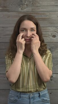 Person practicing EFT. Female tapping under eye (UE) meridian point. Vertical video.