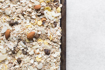 Top view of oat muesli in a baking tray, overhead view of muesli with oats almonds raisins and cornflakes