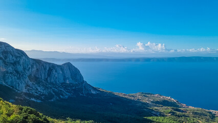 Panoramic aerial view of the Makarska Riviera seen from skywalk in Biokovo nature park, Dalmatia, Croatia. Majestic karst coastline of Adriatic Mediterranean sea in summer. Tranquil serene atmosphere