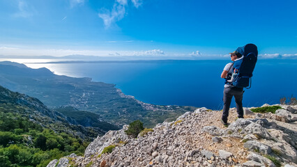 Father with baby carrier on top of mount Sinjal overlooking Biokovo nature park, Makarska,...