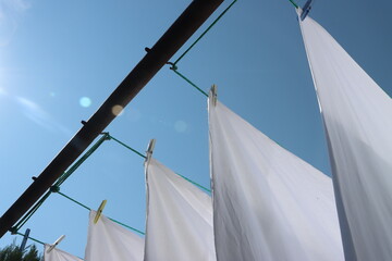 white bed linen hanging outside on a line