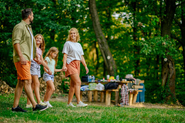 A happy family holding hands and going for a walk in nature.