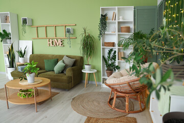 Interior of living room with green plants, sofa and shelf units