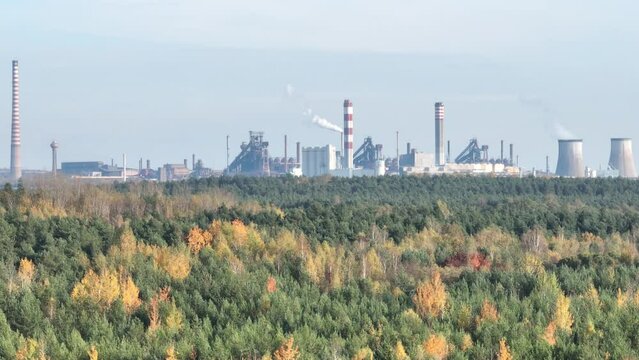 Industrial steel factory, iron works. Metallurgical plant. steelworks. Heavy industry in Europe. Air pollution from chimneys. Ironworks on a background of blue lake. Drone fly above lake to iron works