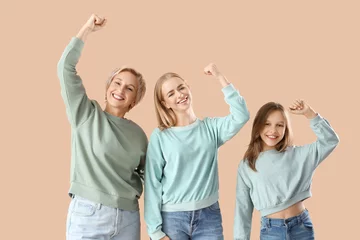 Fotobehang Happy little girl with her mom and grandmother on beige background © Pixel-Shot