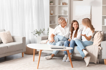 Little girl with her mom and grandmother talking on sofa at home