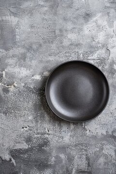 A black plate on a table, suitable for food and dining concepts