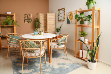 Interior of cozy room with plants, dining table and shelf units