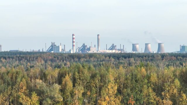 Industrial steel factory, iron works. Metallurgical plant. steelworks. Heavy industry in Europe. Air pollution from chimneys. Ironworks on a background of blue lake. Drone fly above lake to iron works