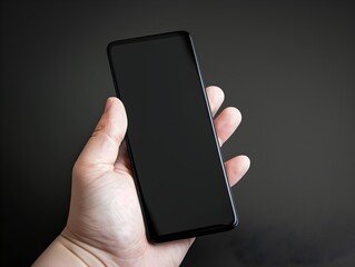 Hand holding the black smartphone with blank screen and modern frameless design