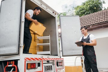 Uniformed removal company workers unload boxes and furniture from the truck exhibiting excellent...