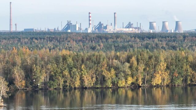 Industrial steel factory, iron works. Metallurgical plant. steelworks. Heavy industry in Europe. Air pollution from chimneys. Ironworks on a background of blue lake. Drone fly above lake to iron works