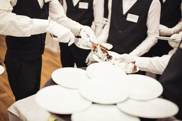 Waiters cut the wedding cake. Banquet. Piece of wedding cake. detail of luxury wedding Dessert....