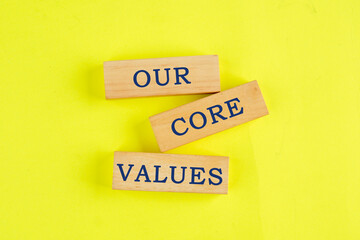 Concept words OUR CORE VALUES symbol on wooden blocks on a lemon background. Business concept