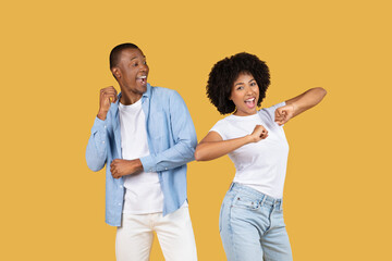 Energetic young couple playfully dancing and pointing, full of joy and excitement