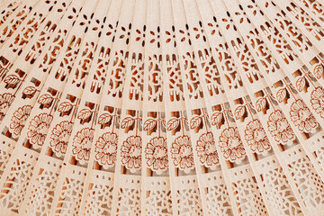 Wooden open fan with pattern. Natural background, texture