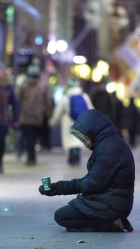 Unidentified homeless man begging on the street of European city winter
