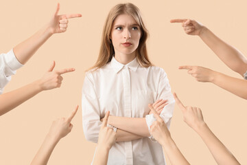 People pointing at young woman on beige background. Accusation concept