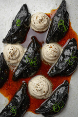 Black ravioli made from squid ink with spicy creamy sauce.	