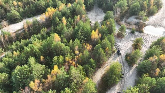 Drone view Offroad 4x4 sand rally, quad bike, motocross, atv ,off road cars in cross country competition. Aerial drone view of quad bikes riding in sand in forest.