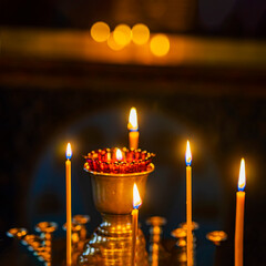 Candles are lit in gold vase, warm and sad concept
